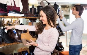 Smiling young couple buying winter shoes in a shoe store