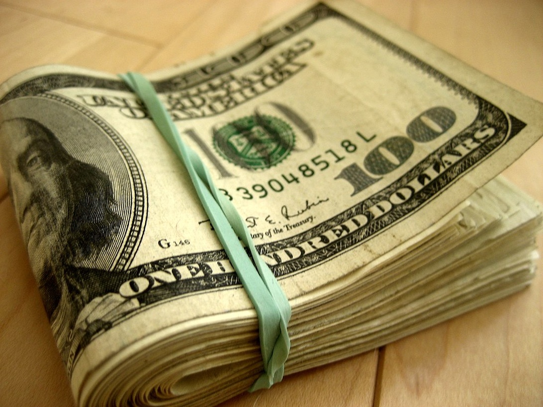 En bunke med amerikanske 100-dollarsedler, som symboliserer valutaens rolle i inflasjonsbildet.